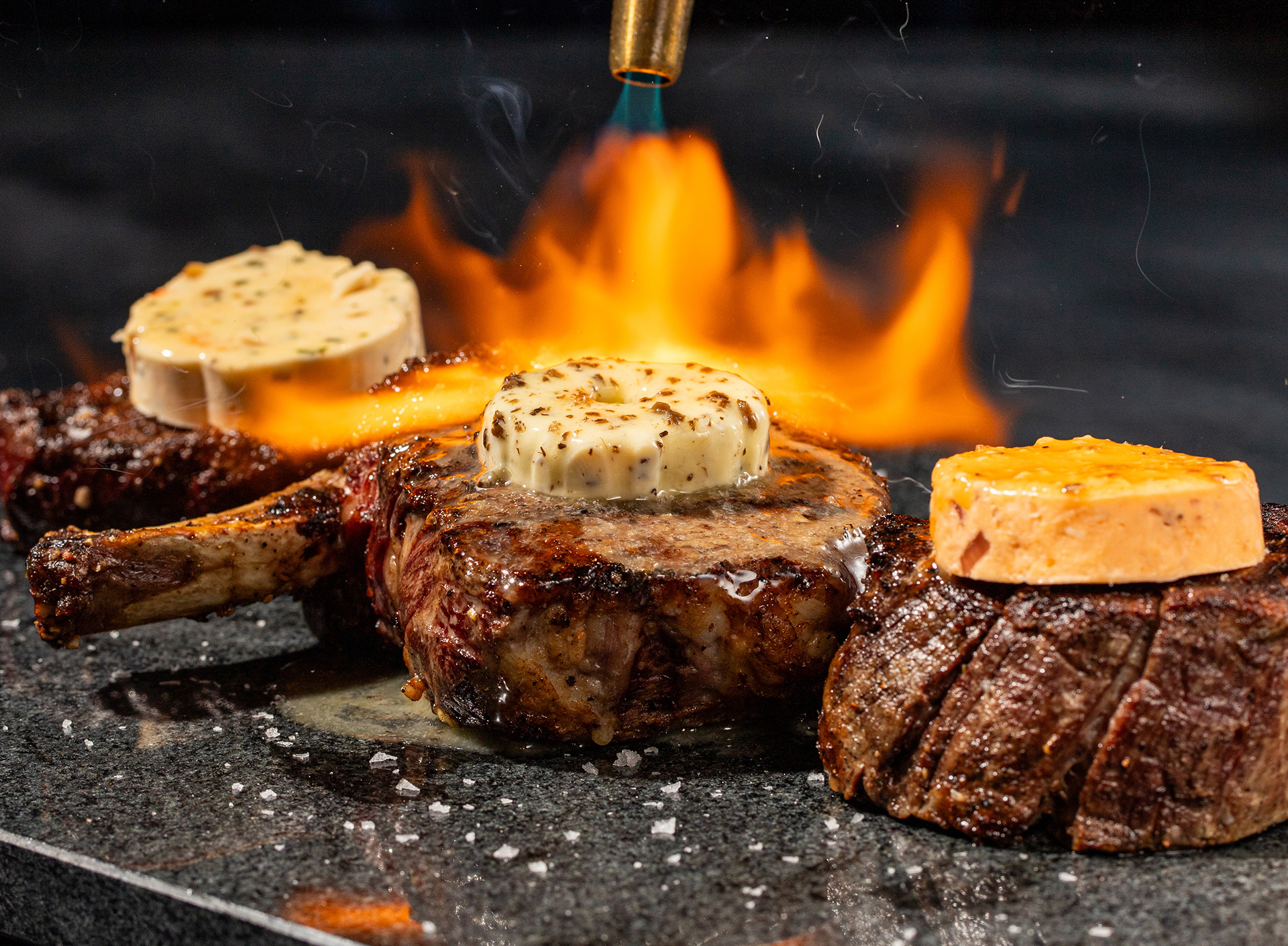 Trio of STK steaks finished with compound butters under open flame
