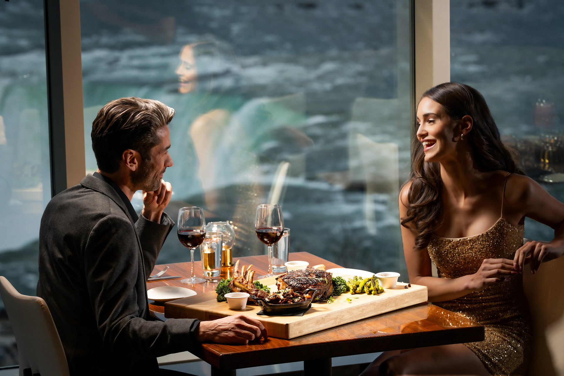 A couple dining at STK Niagara Falls with the Falls visible through the window