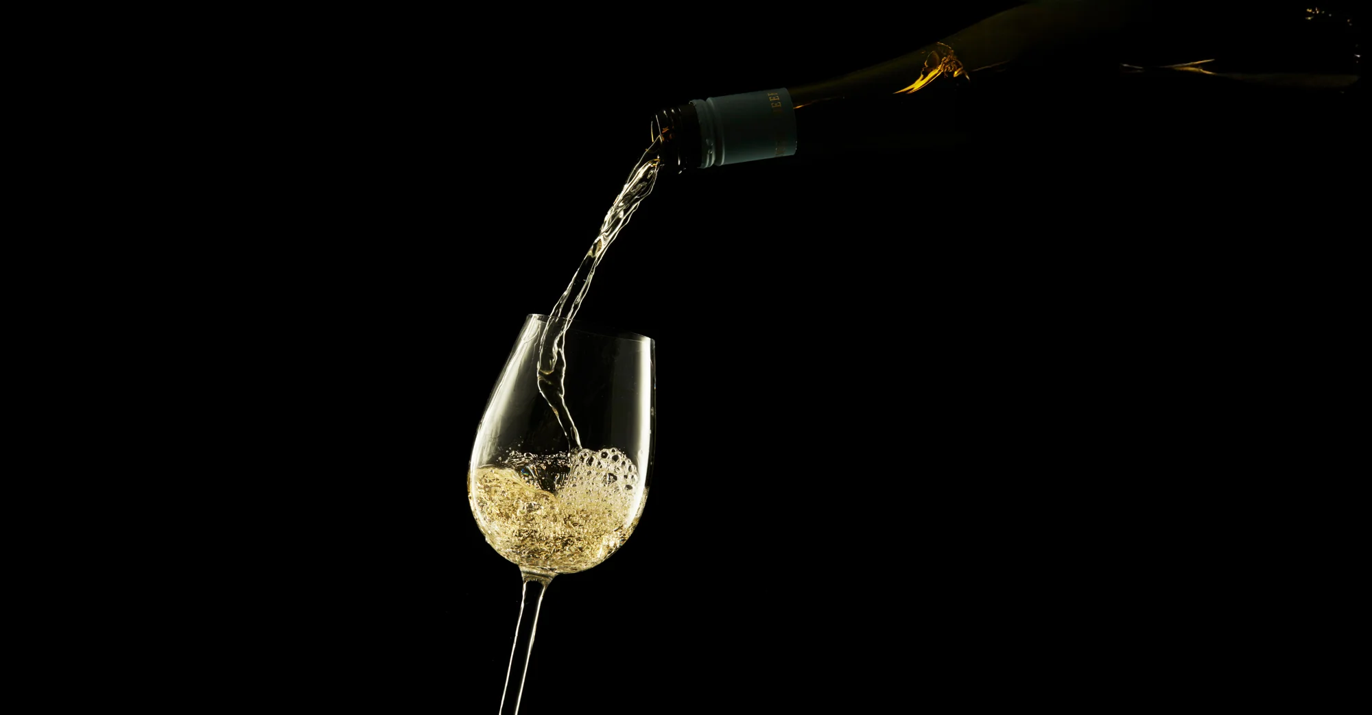 A chilled bottle of white wine pouring into stemware at STK Niagara Falls