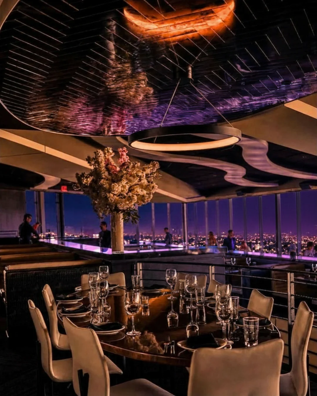 Private wedding reception table set with stemware and a floral centerpiece beside the Fallsview windows at STK Niagara Falls